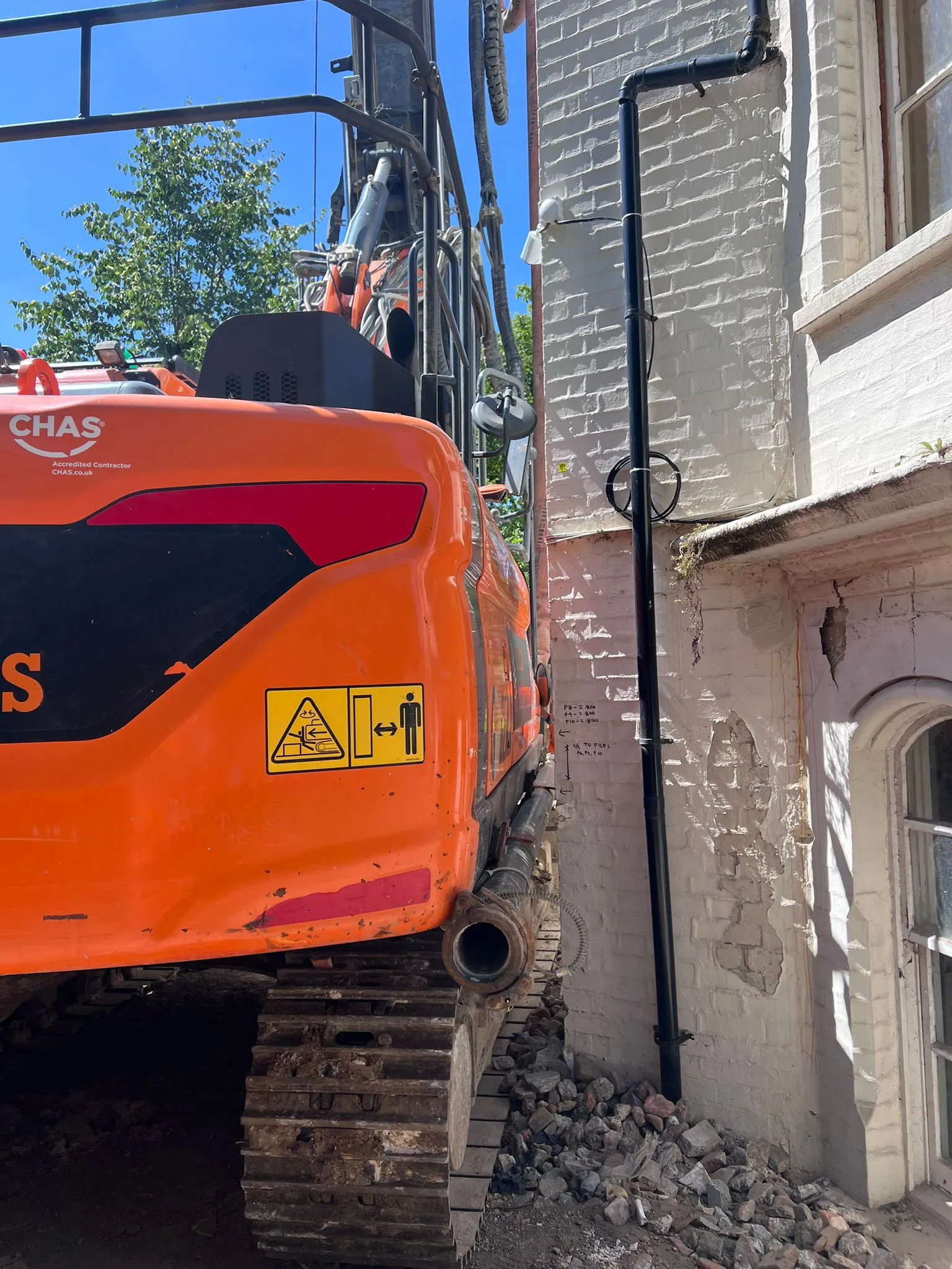 A construction vehicle parked next to a building.