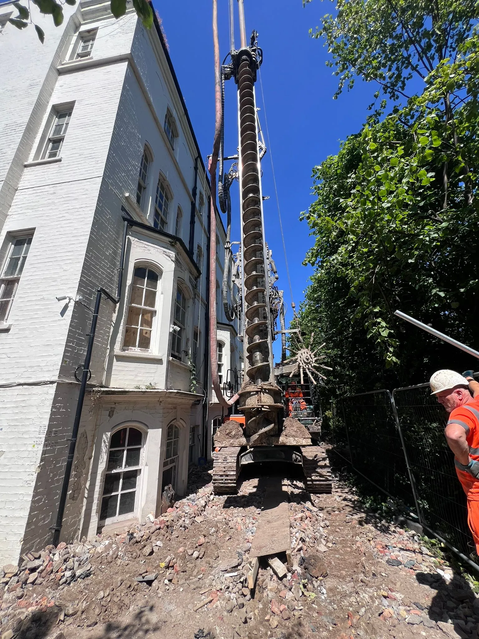 A man in an orange shirt and a crane.