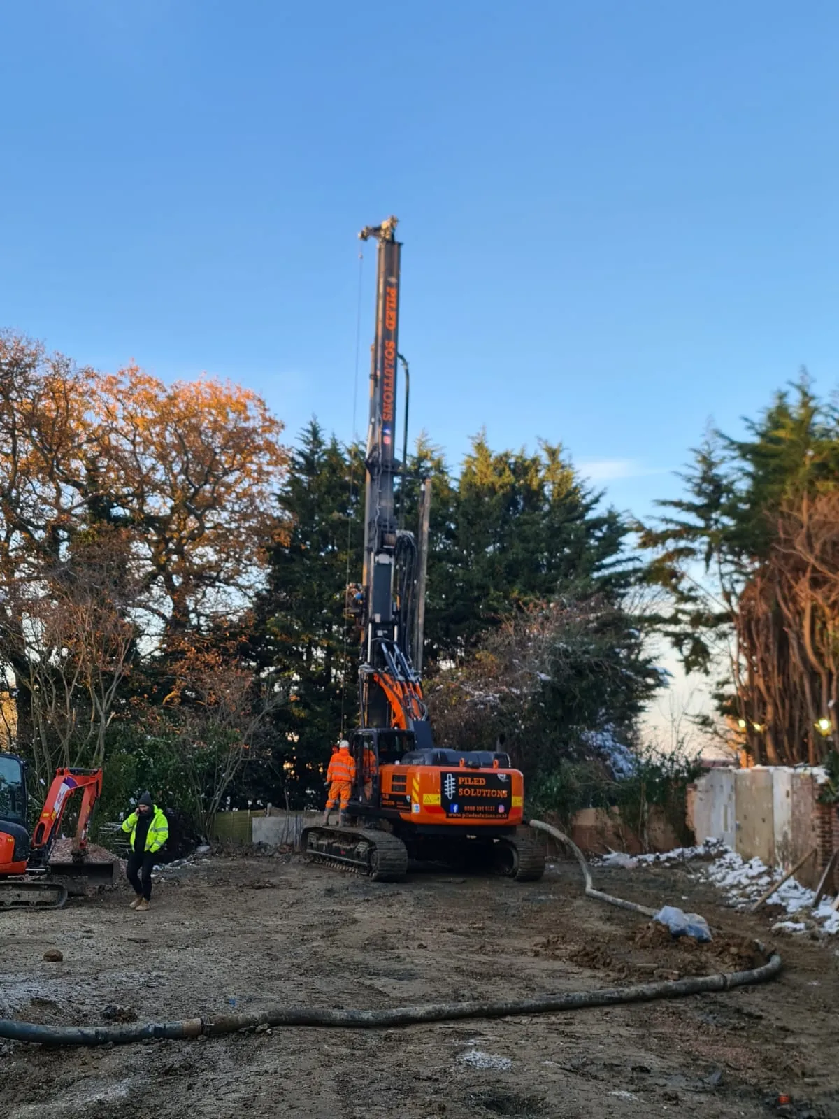 A couple of men standing on top of a pile of dirt.