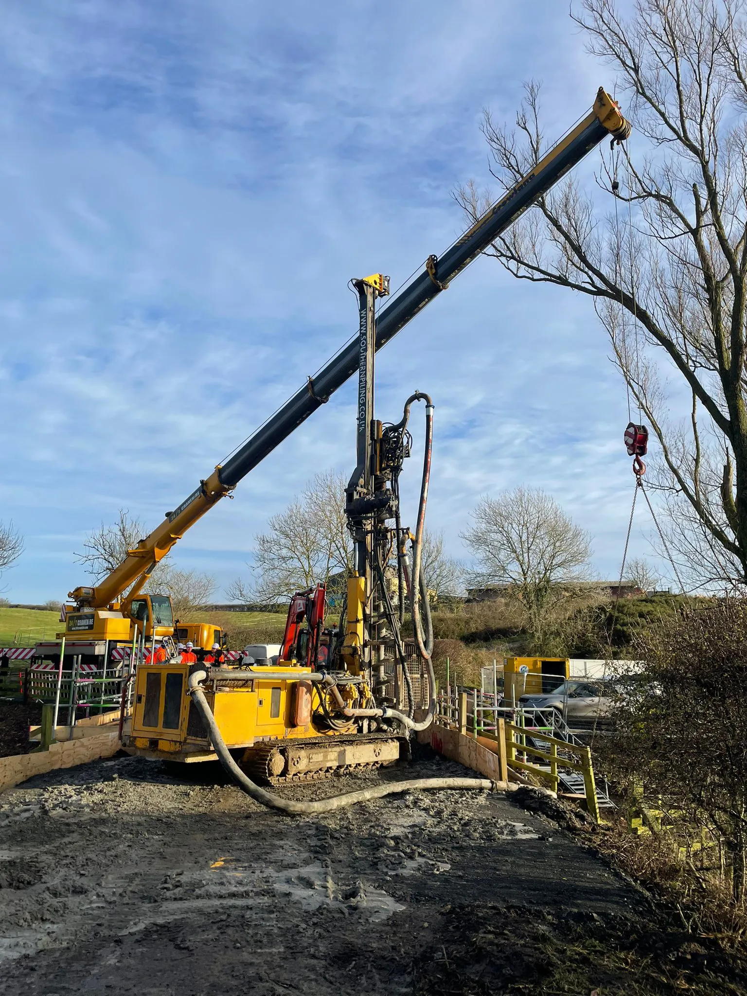 A yellow and black machine is in the dirt.